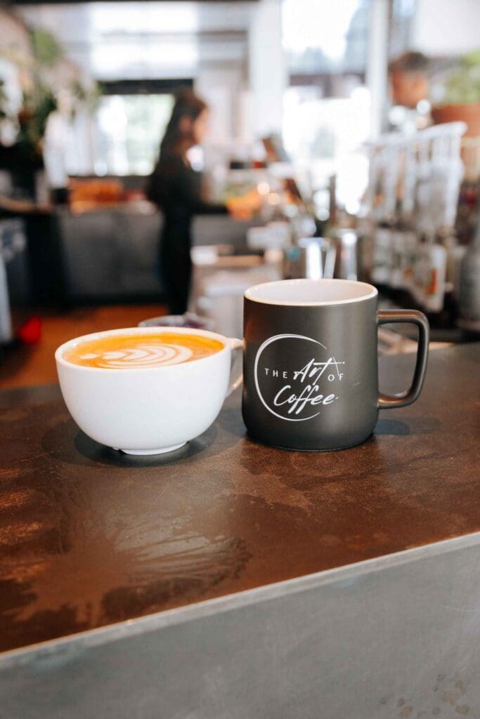 Latte in a mug and a decorative mug inside the Kirkland coffee shop